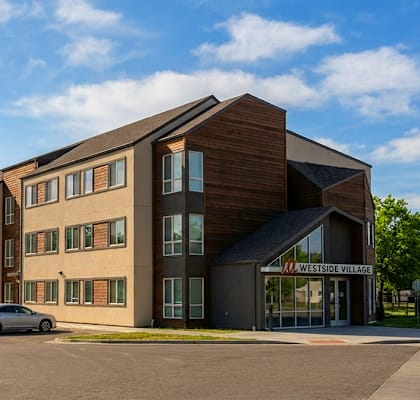 A modern building with a parking lot in front.