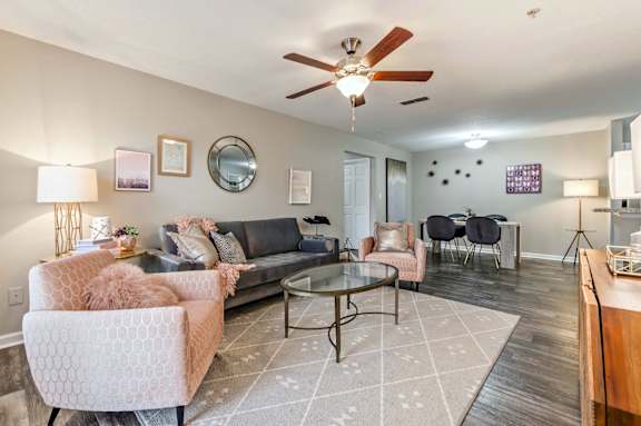 a living room with furniture and a ceiling fan