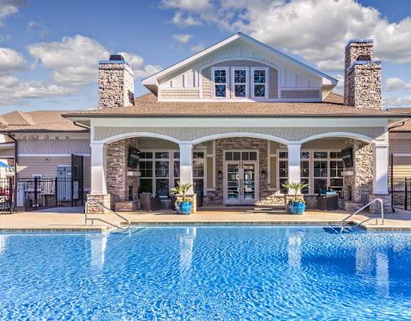 A large house with a pool in front.