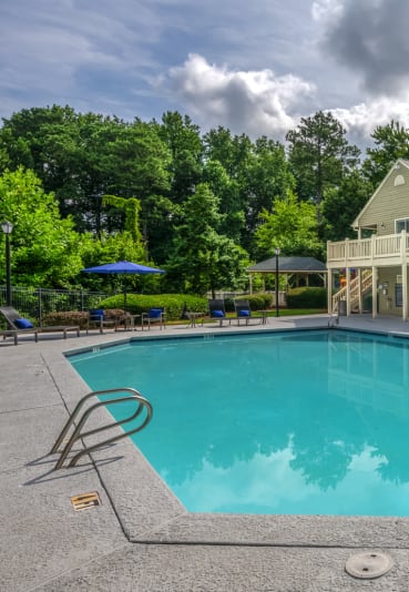 a swimming pool with a house in the background