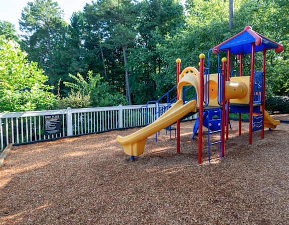 a childrens playground with a slide at a park