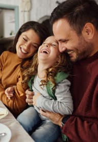 a man and two women laughing while sitting on a table