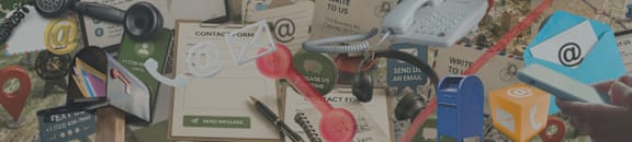 A cluttered desk with various communication devices and papers.