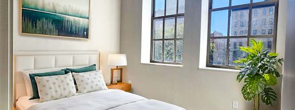 a bedroom with a bed and a large window