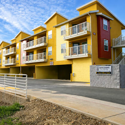 A yellow apartment building with a sign that says "East Mead".