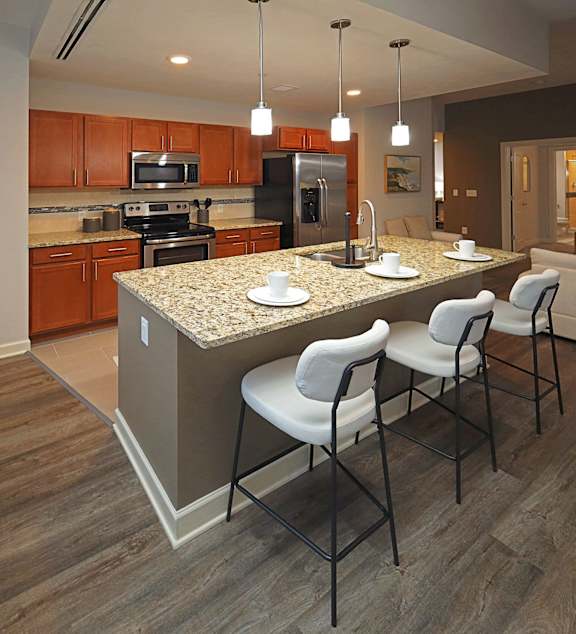 A modern kitchen with a dining table and chairs in the middle of the room.