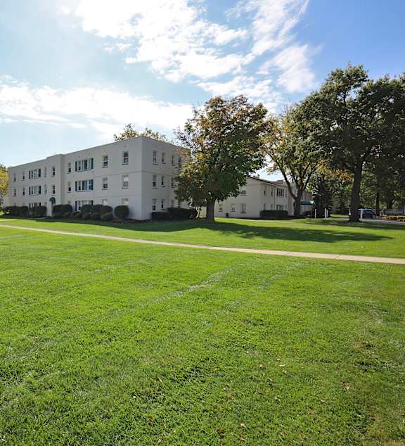 A white building with a green lawn in front of it.