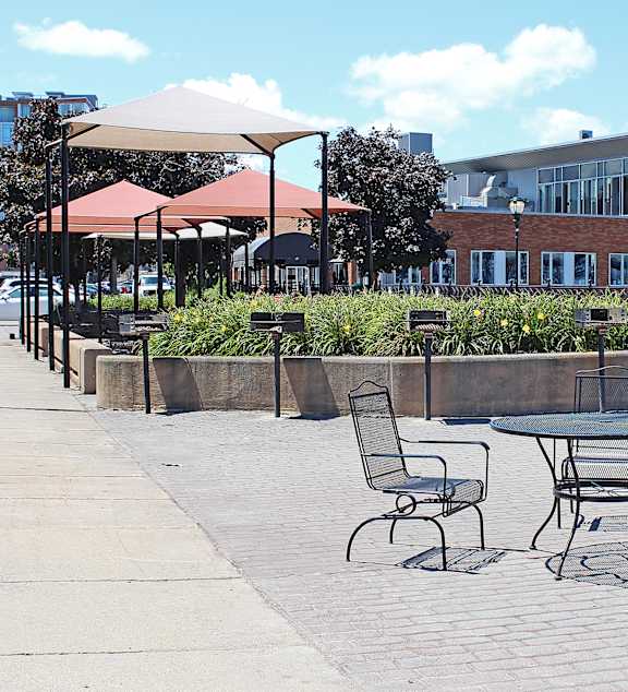 A patio with tables and chairs and umbrellas.