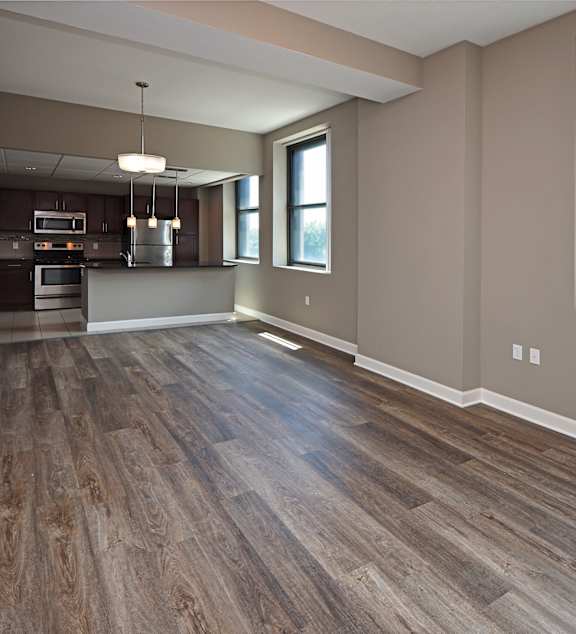 A kitchen with wood flooring and a window.