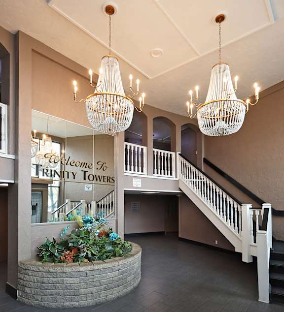 A large chandelier hangs from the ceiling above a staircase.