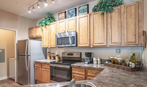 a kitchen with wooden cabinets and stainless steel appliances
