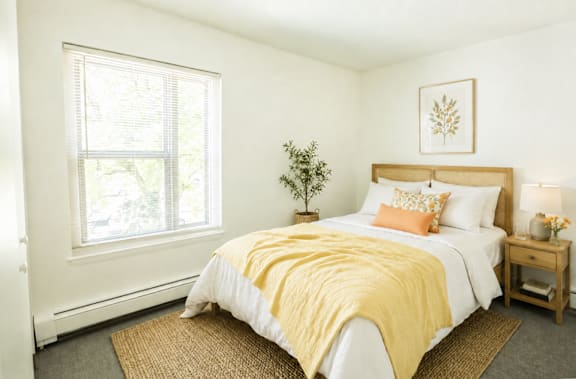 A bedroom with a bed, a bench, and a wall art.