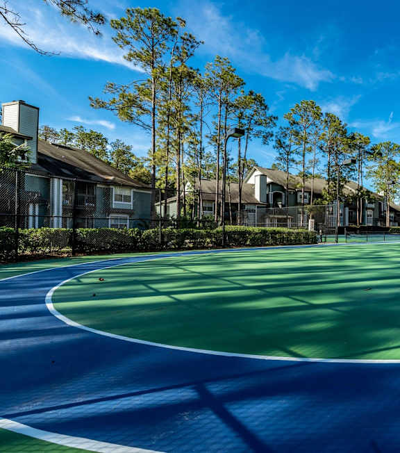 A basketball court with a yellow backboard and a basketball hoop. at Park Place Oviedo Apartments, Oviedo, FL