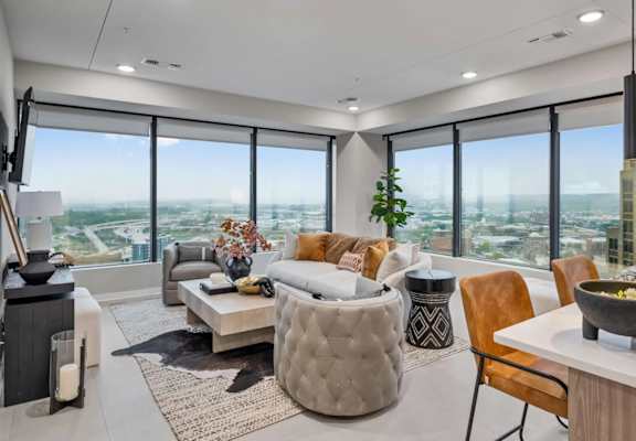 A modern living room with a large window overlooking the city.