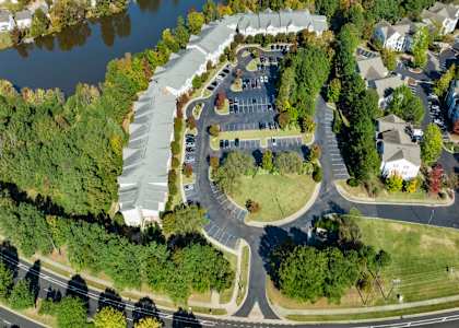 An aerial view of a roundabout with a building and trees.