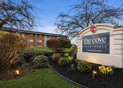The Cove Apartments is a residential complex with a well-maintained garden in front.