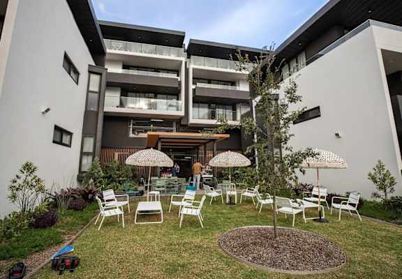 an outdoor area with chairs and umbrellas in front of a building