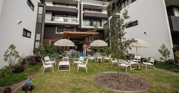 an outdoor area with chairs and umbrellas in front of a building