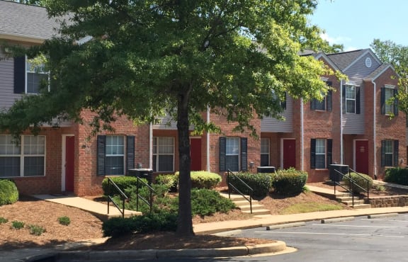 A tree in front of a red brick building.