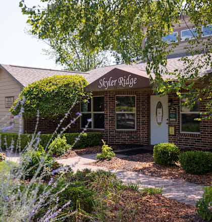 A warm and inviting clubhouse with large windows and a well-lit entrance.