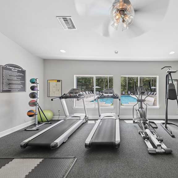 Bright resident fitness center at Lancaster Place Apartments in Calera, Alabama featuring treadmills, weight equipment, and spacious workout areas.