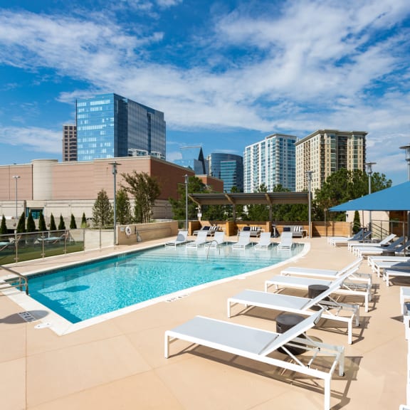 an image of a hotel pool with a city skyline in the background