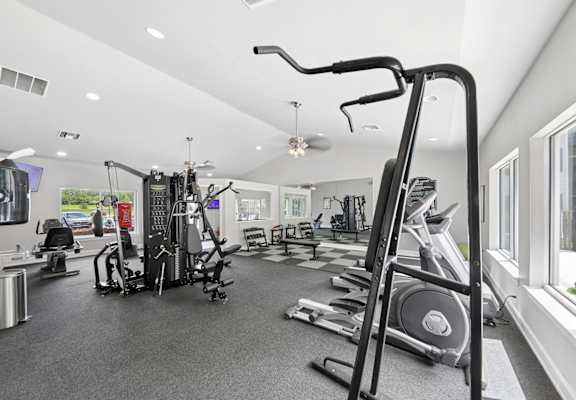 Modern fitness center at Lancaster Place Apartments in Calera, AL with strength training equipment and cardio machines for residents.