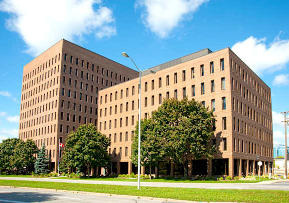 A city street with a large building on the right and a smaller one on the left.