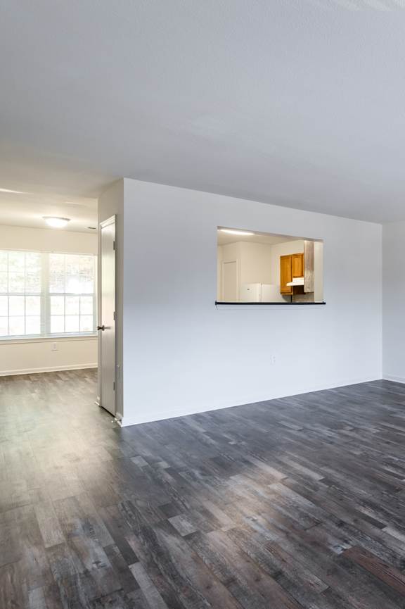 an empty living room with white walls and wood floors at Crescent Pointe, Stafford, VA