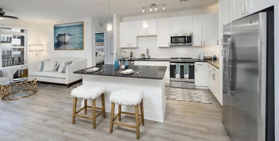A modern kitchen with a bar stool and a fridge.