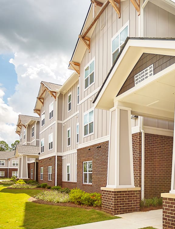 A row of townhouses with a balcony on the second floor.
