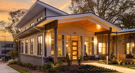 A modern house with a front porch and a walkway leading to the front door.