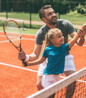 a man and a little girl on a tennis court