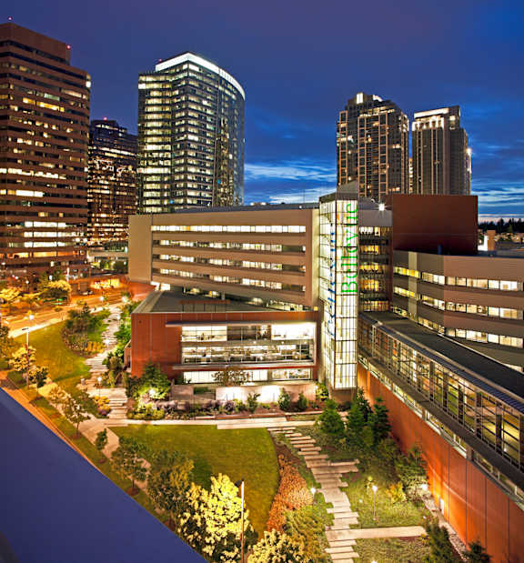 A cityscape at night with a large building in the foreground.