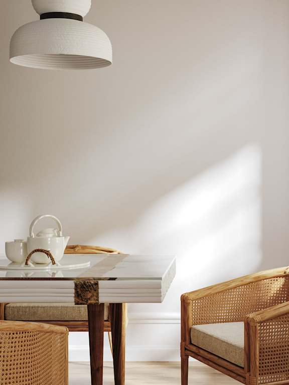 A modern kitchen with a white island and wooden chairs.