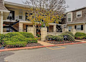 Thumbnail 2 of 25 - Exterior image of Deauville apartments with trees and bushes