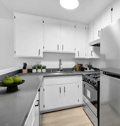 a kitchen with stainless steel appliances and white cabinets