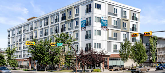 a white apartment building on the corner of a city street