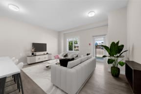 a living room with a white couch and a table and a television