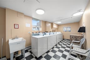 a public restroom with sinks and chairs and a checkered floor