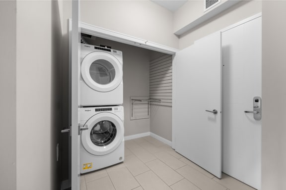a white washer and dryer in a laundry room with a white door