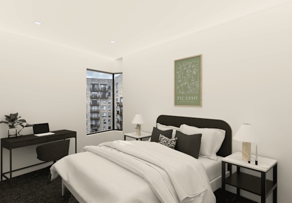 A bedroom with a large bed, a desk with a chair, and a framed picture on the wall.