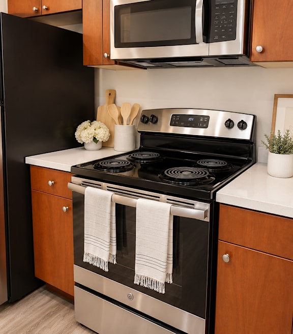 A kitchen with a stainless steel refrigerator and wooden cabinets.