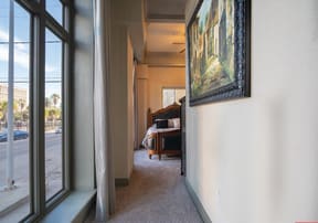 a hallway with large windows and a painting on the wall