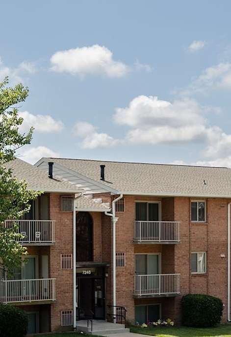 Apartment building with a tree in front of it.