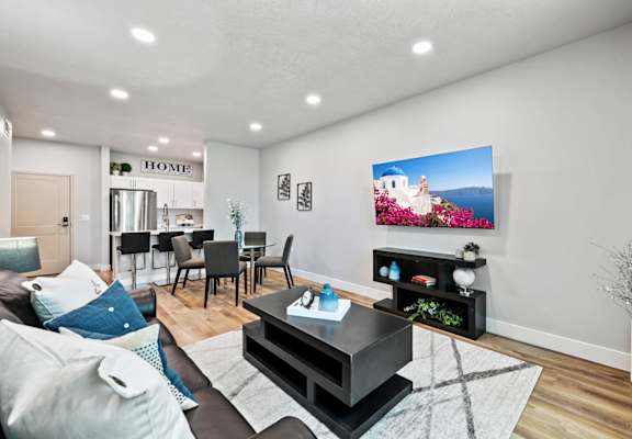 a living room with a couch a table and a tv on the wall