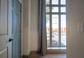 a view of a window with a blue door and a curtain