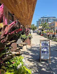 A sign that says Vaza con Vino is on a sidewalk.