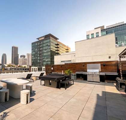 A rooftop patio with a table and chairs overlooking a city skyline.