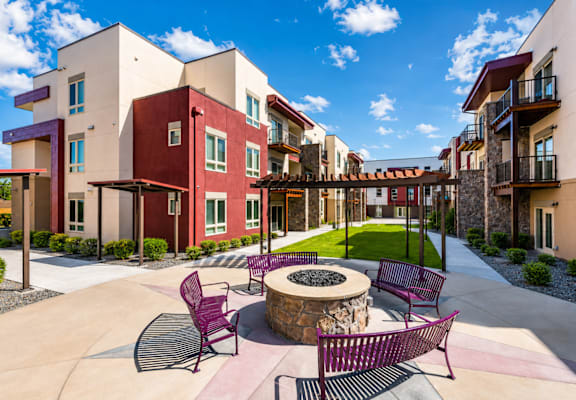 A courtyard with a fire pit and chairs.